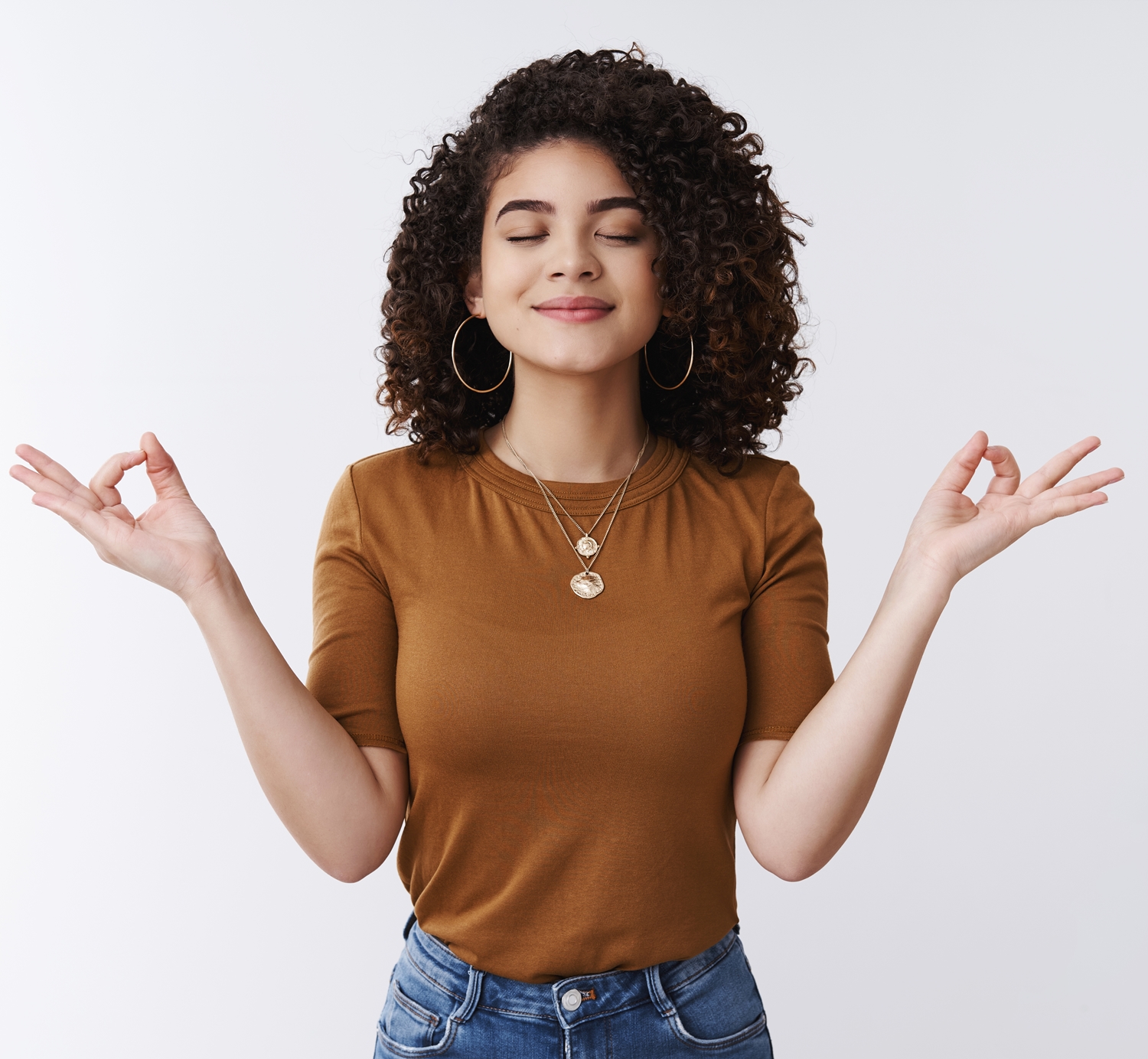 Om girl feels peace patience. Attractive carefree relaxed happy young woman curly shirt hairstyle close eyes smiling delighted meditating hands sideways nirvana lotus pose, breathing practice yoga.